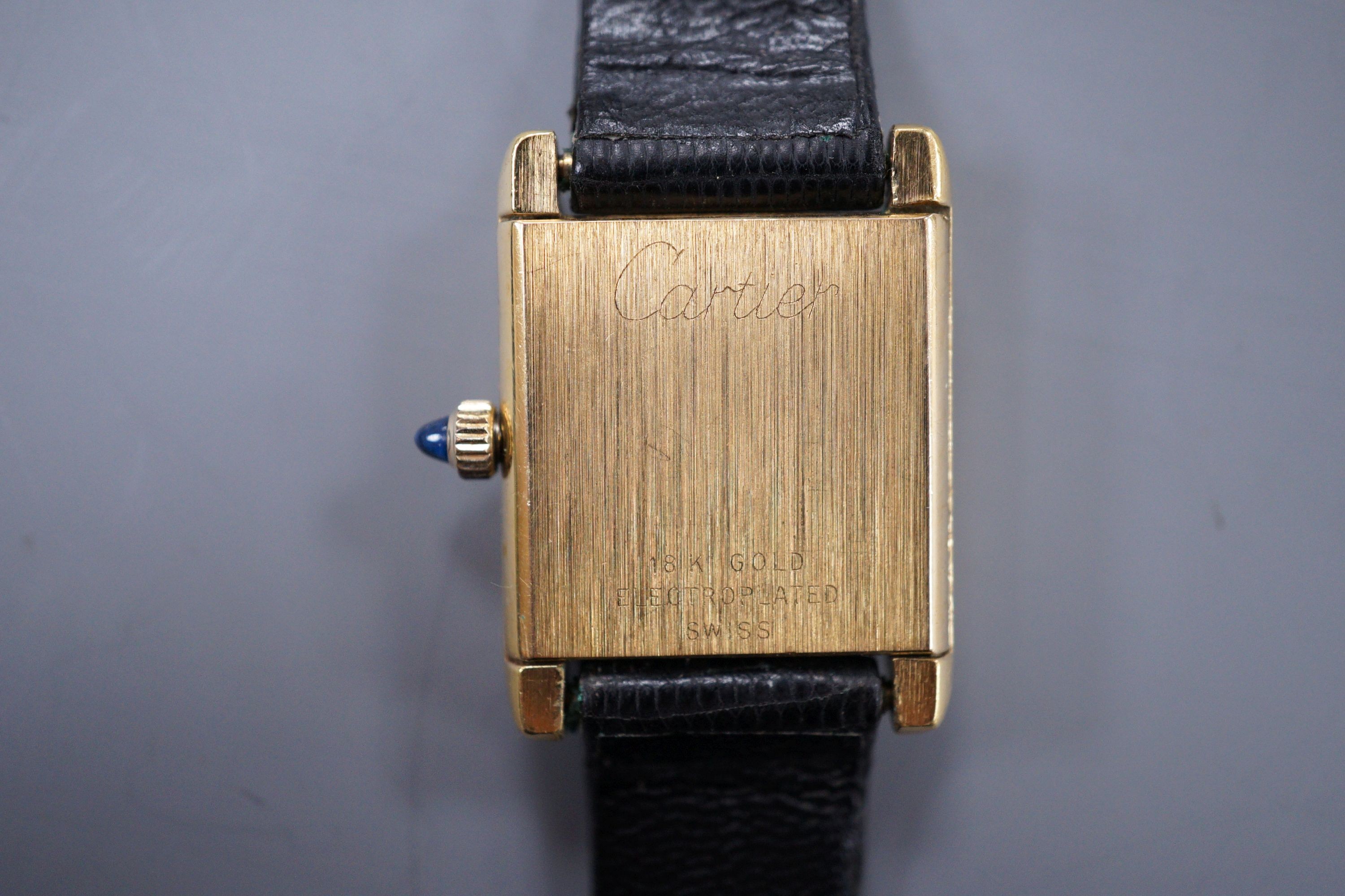 A ladies gold plated Cartier tank wrist watch, with cabochon set winder.